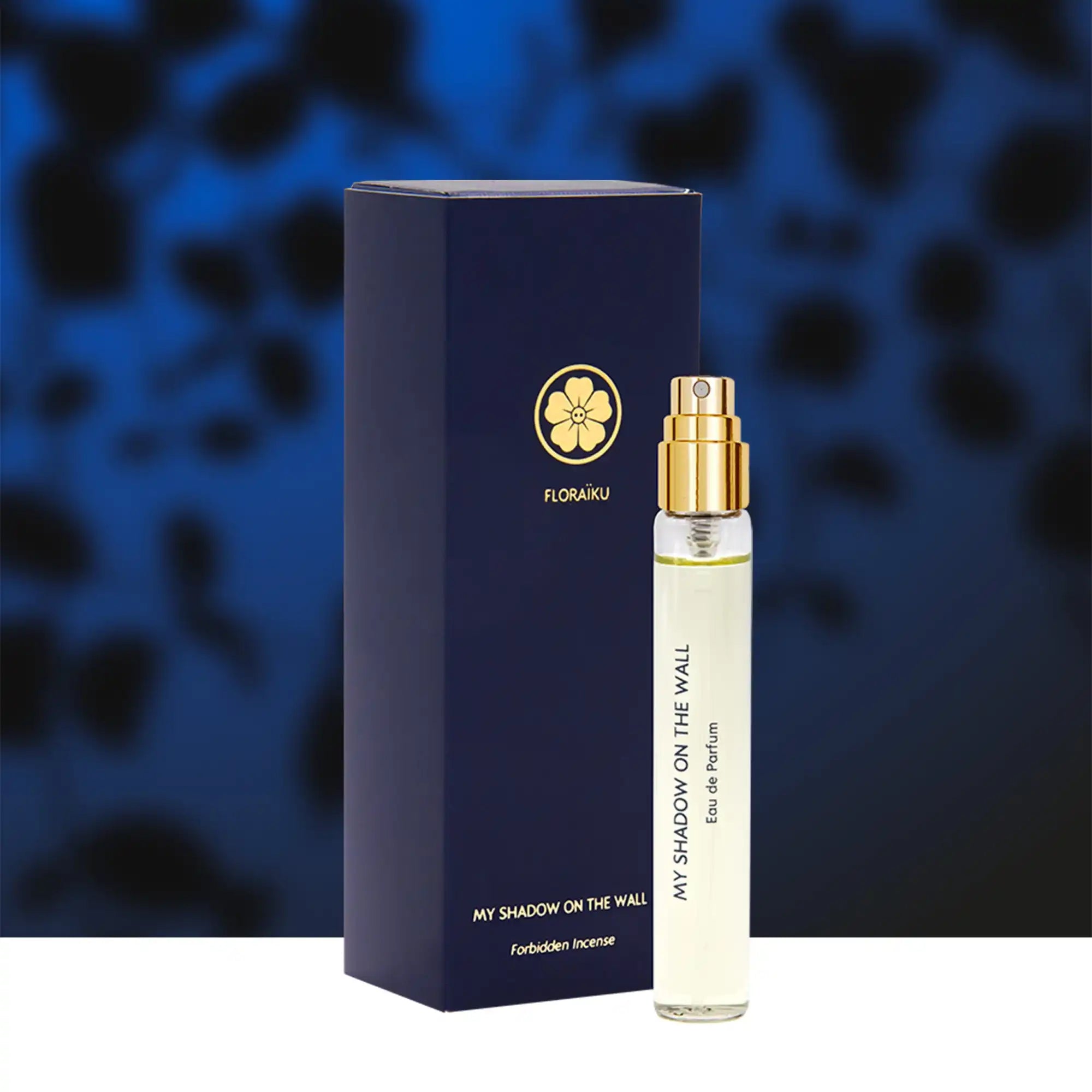 Luxury perfume bottle and navy blue packaging box with a gold floral logo.