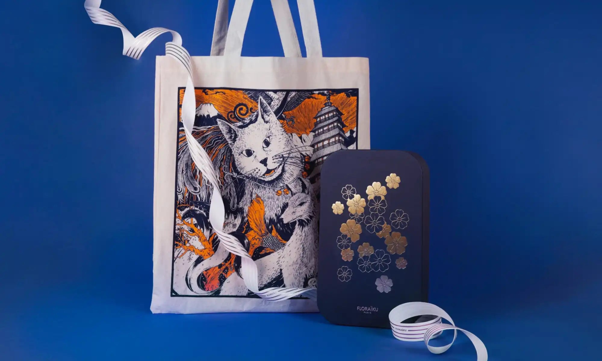 White tote bag with a cat illustration featuring orange and black artwork.